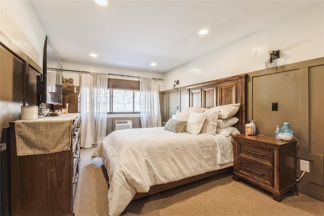 bedroom with a wall mounted air conditioner and light carpet