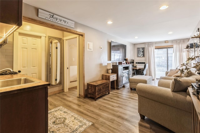 living room with sink and light hardwood / wood-style flooring