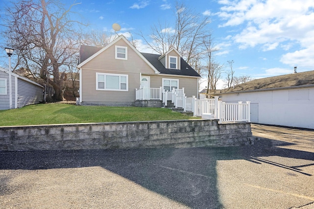 cape cod-style house featuring a front yard