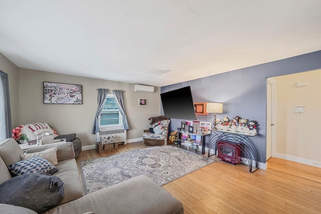 living room with a wall mounted air conditioner and light wood-type flooring