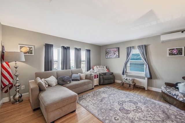 living room featuring radiator heating unit, a wealth of natural light, wood-type flooring, and a wall mounted AC