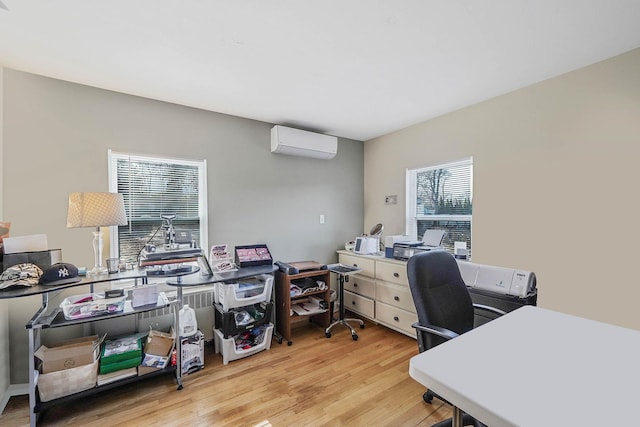 office area with an AC wall unit and light wood-type flooring