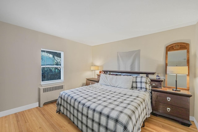 bedroom featuring radiator and light hardwood / wood-style flooring