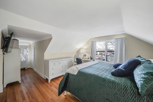 bedroom featuring cooling unit, light hardwood / wood-style flooring, and vaulted ceiling