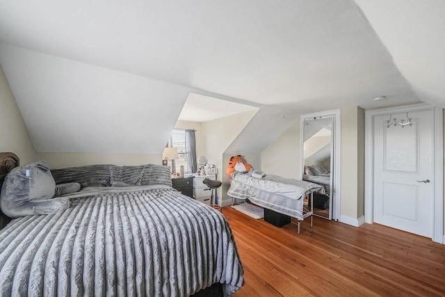 bedroom with lofted ceiling and hardwood / wood-style floors