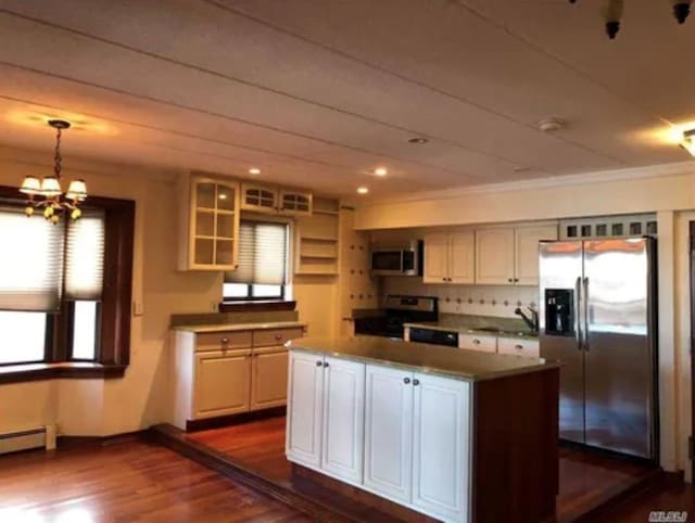 kitchen featuring pendant lighting, appliances with stainless steel finishes, dark hardwood / wood-style floors, white cabinets, and a kitchen island