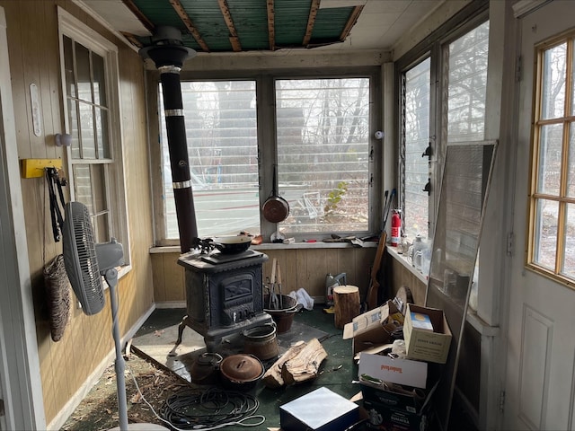 miscellaneous room featuring a wood stove and wooden walls