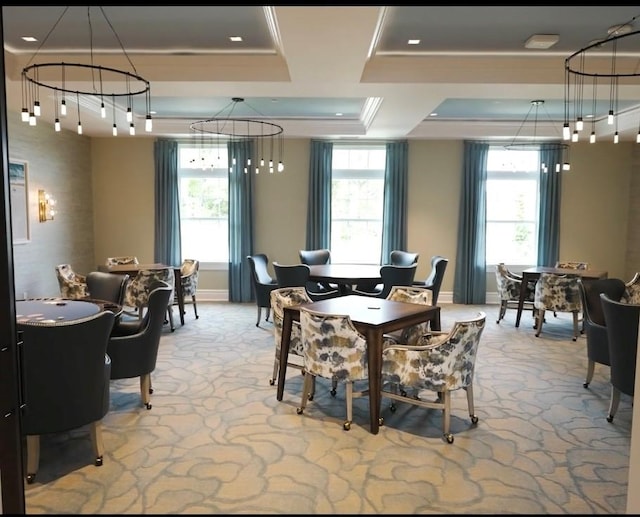 carpeted dining area with ornamental molding and a raised ceiling