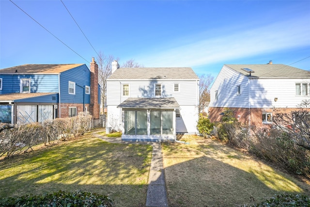 rear view of house featuring a sunroom and a yard