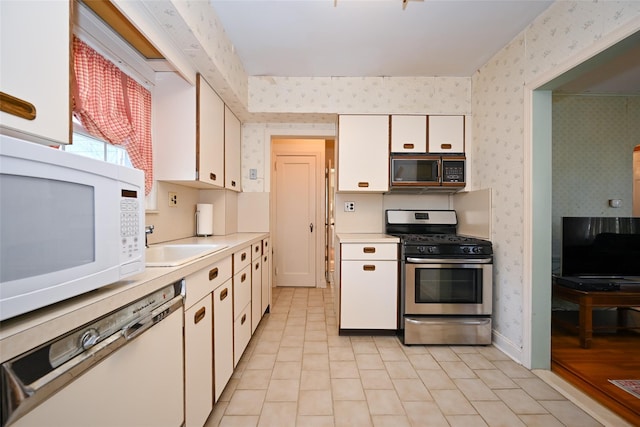 kitchen featuring sink, white appliances, and white cabinets