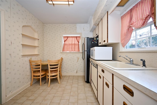 kitchen featuring sink, white appliances, and white cabinets