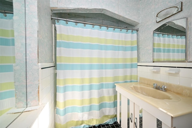 bathroom featuring sink and tile walls