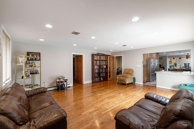 living room featuring a baseboard radiator and light wood-type flooring