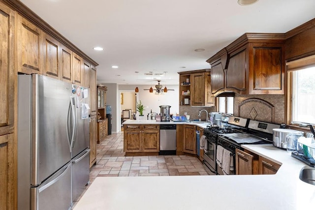 kitchen featuring decorative light fixtures, decorative backsplash, ceiling fan, kitchen peninsula, and stainless steel appliances