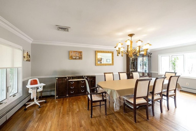 dining area featuring hardwood / wood-style flooring, ornamental molding, baseboard heating, and a notable chandelier