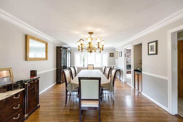 dining area with ornamental molding, dark hardwood / wood-style flooring, and a chandelier