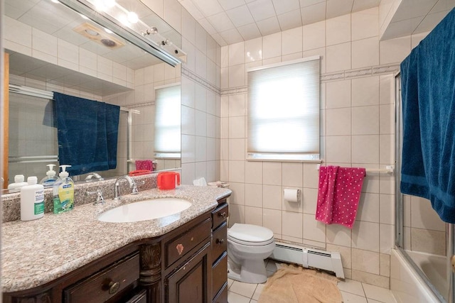 full bathroom featuring baseboard heating, tile walls, vanity, tile patterned floors, and toilet