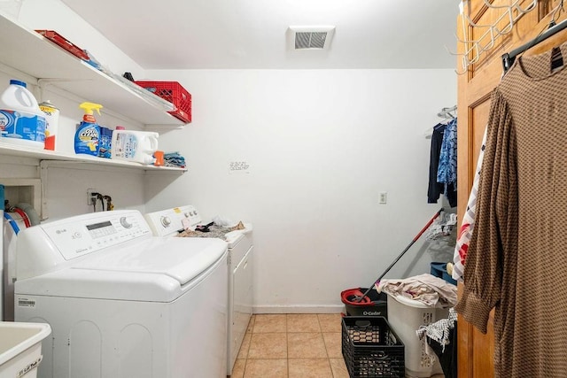 clothes washing area featuring light tile patterned flooring and independent washer and dryer