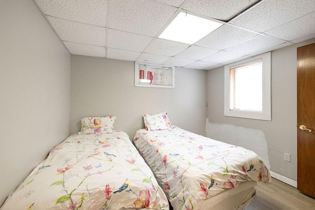 bedroom featuring a paneled ceiling and light wood-type flooring