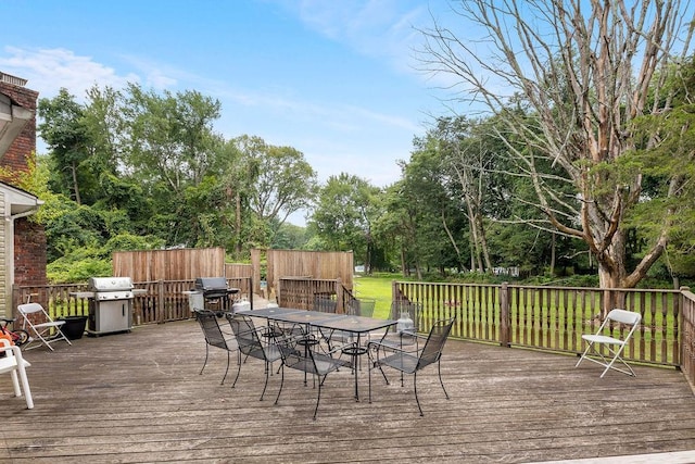 wooden deck featuring a grill and a yard