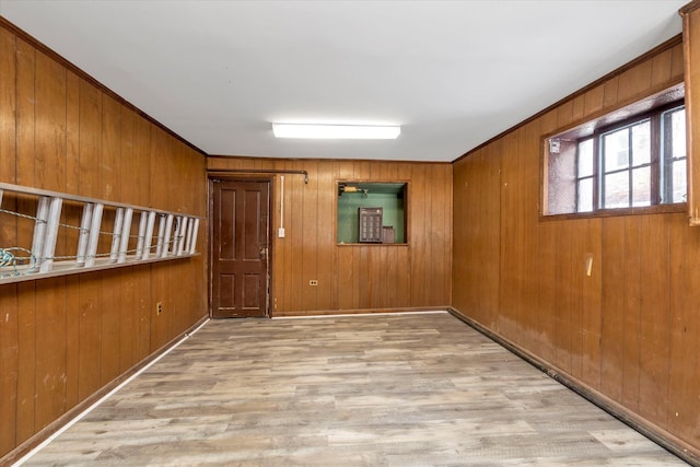 unfurnished room with wooden walls and light wood-type flooring