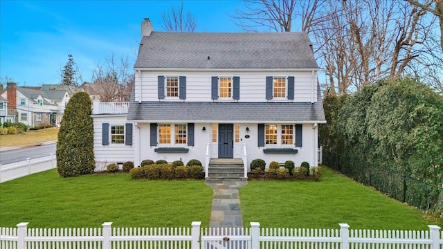 view of front of property featuring a fenced front yard, roof with shingles, a chimney, and a front lawn