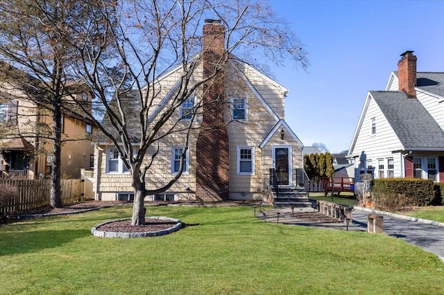 back of property featuring a yard, fence, and a chimney