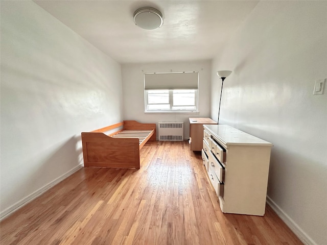 bathroom with radiator and wood-type flooring