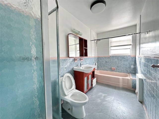 bathroom with tile walls, vanity, and toilet