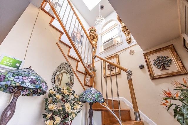 stairway featuring cooling unit and a skylight