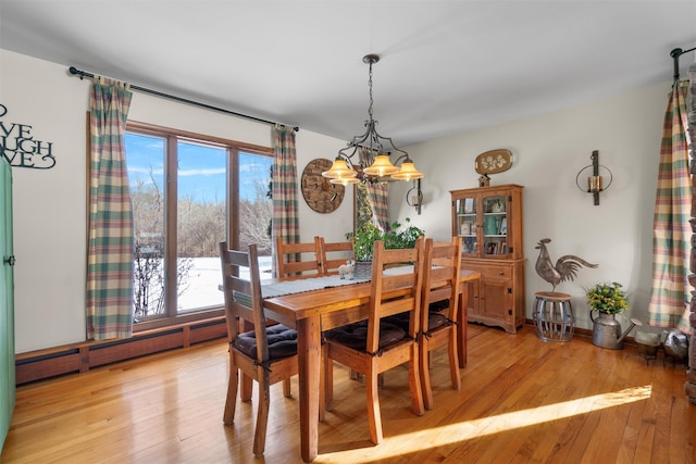 dining space featuring baseboard heating, a chandelier, and light wood-type flooring