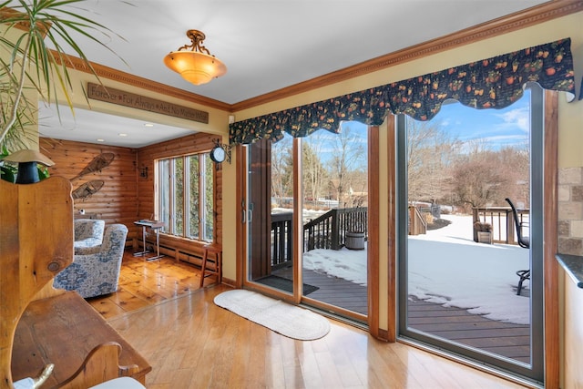 doorway with log walls, ornamental molding, baseboard heating, and hardwood / wood-style flooring