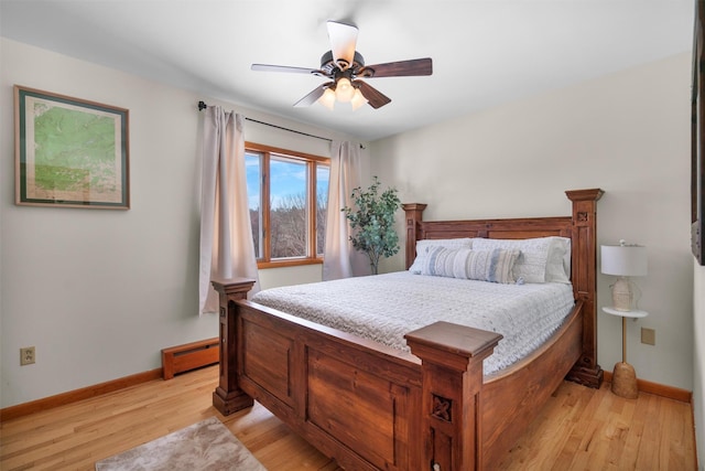 bedroom with ceiling fan, a baseboard radiator, and light wood-type flooring