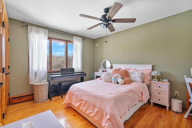 bedroom featuring light wood-type flooring, ceiling fan, and baseboard heating