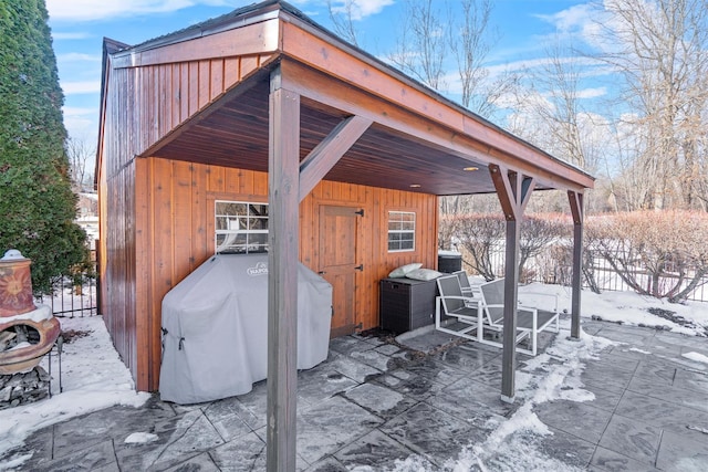 snow covered patio with an outdoor structure