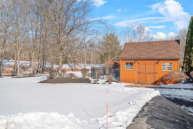 yard layered in snow with an outbuilding