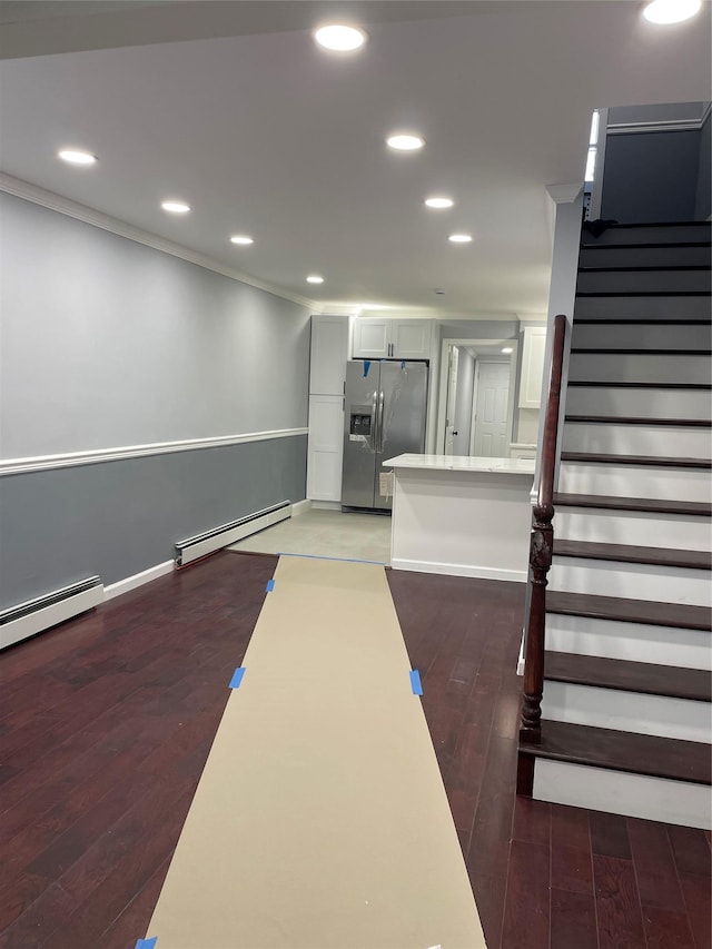 interior space with dark wood-type flooring, a baseboard radiator, and ornamental molding