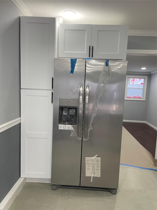 kitchen featuring ornamental molding, light tile patterned floors, and stainless steel fridge with ice dispenser