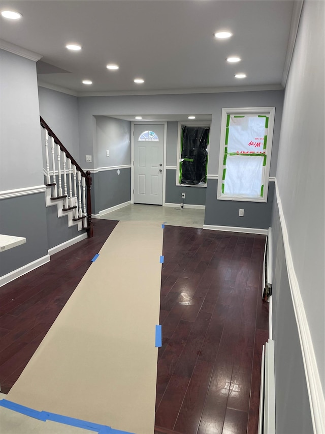 foyer entrance featuring baseboard heating, ornamental molding, and dark hardwood / wood-style flooring