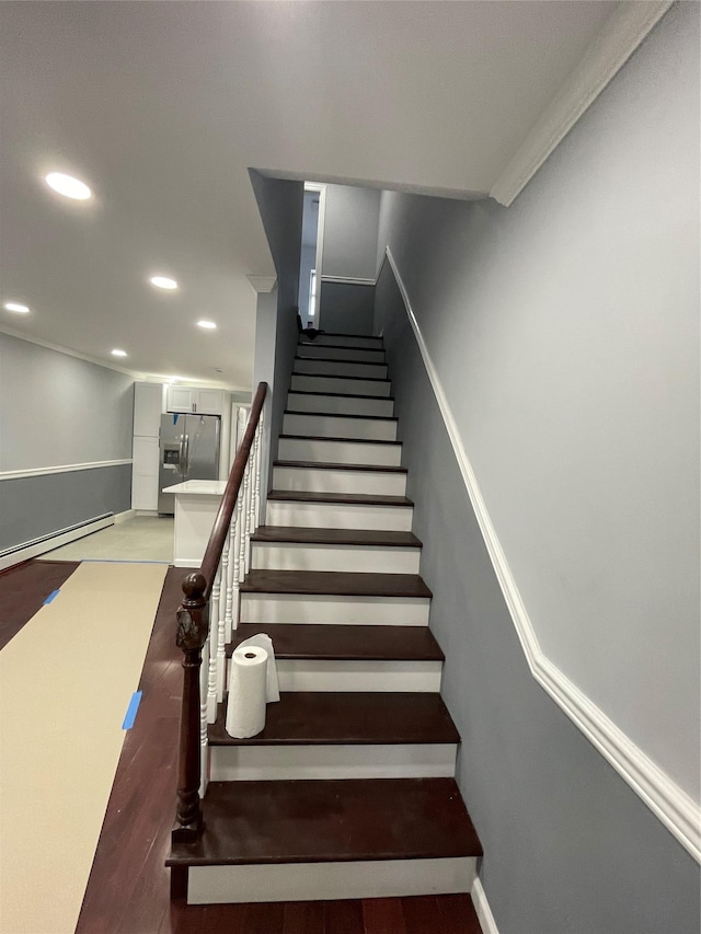 staircase featuring hardwood / wood-style flooring and baseboard heating