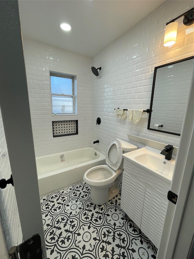 full bathroom with tiled shower / bath, tile walls, vanity, toilet, and tile patterned floors