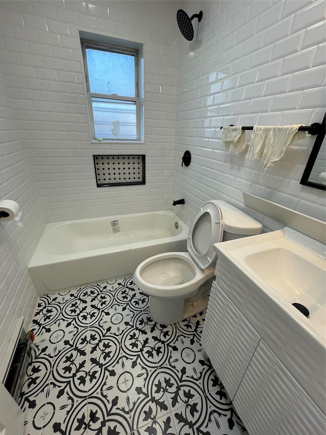 full bathroom featuring tile walls, tiled shower / bath combo, vanity, tile patterned floors, and toilet