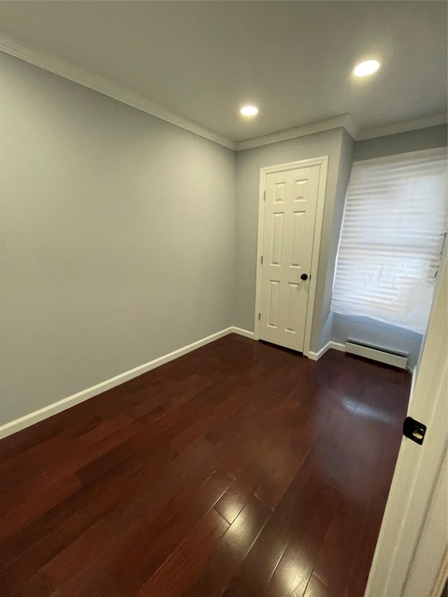 spare room featuring ornamental molding, dark hardwood / wood-style floors, and baseboard heating