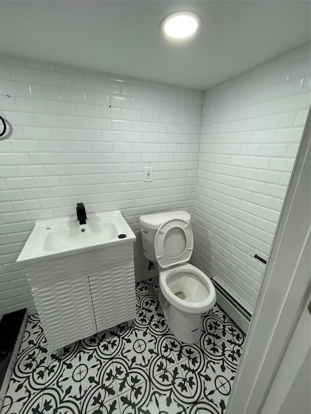 bathroom with tile patterned flooring, vanity, toilet, and baseboard heating