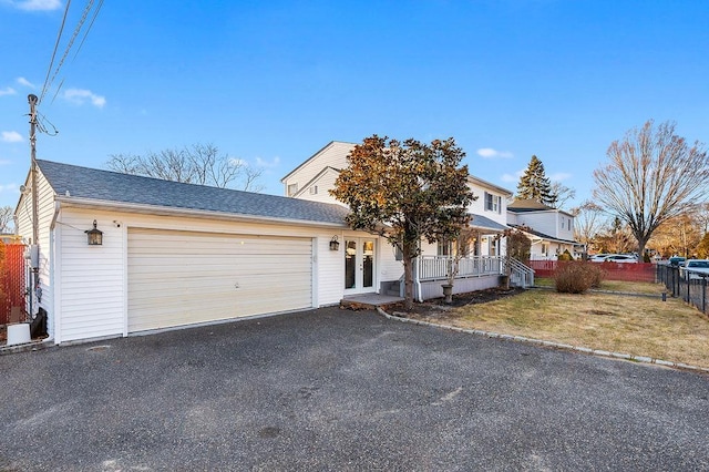 view of front of home featuring a garage, a front yard, and covered porch