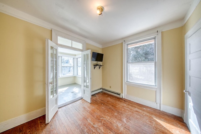 doorway with a baseboard heating unit, baseboards, french doors, wood-type flooring, and crown molding