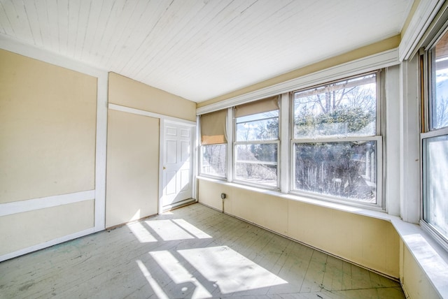 unfurnished sunroom featuring wood ceiling and a wealth of natural light