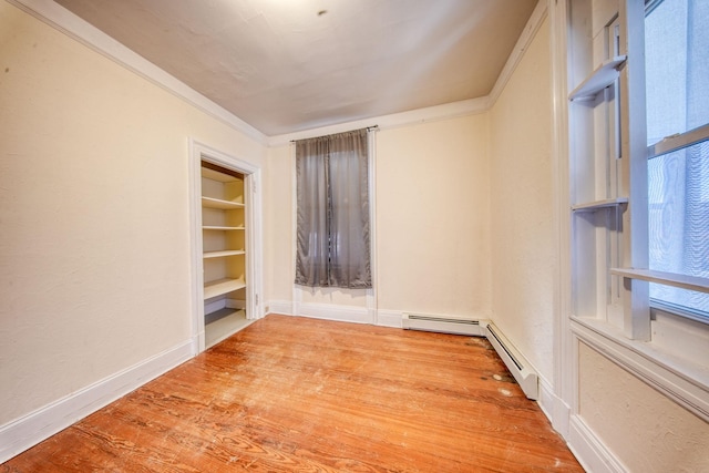 unfurnished room with built in features, ornamental molding, baseboards, and wood finished floors