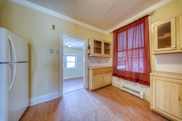 kitchen with a baseboard radiator, light wood-style flooring, baseboards, ornamental molding, and freestanding refrigerator