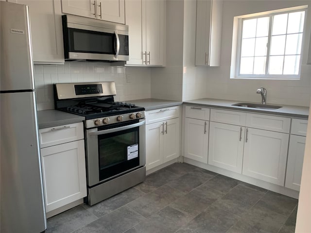 kitchen featuring white cabinetry, stainless steel appliances, sink, and backsplash